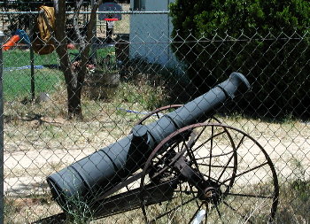 Old cannon, resting on farming gear