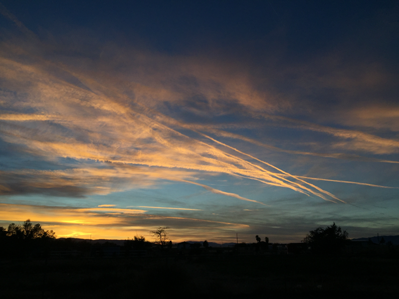 Winter sunset with clouds and contrails